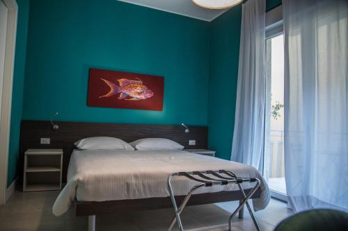 a bedroom with a bed with a fish painting on the wall at RHS - Casa Consani in Ventimiglia