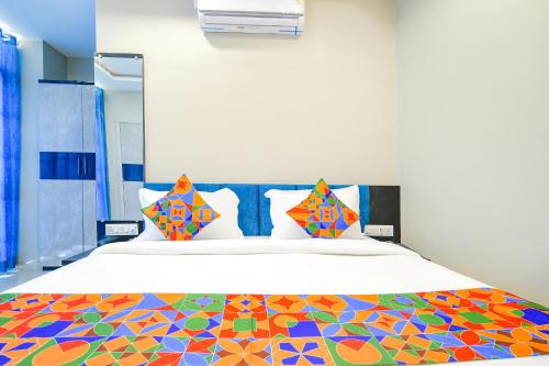 a bedroom with a bed with a colorful bedspread at FabHotel Lake View III in Indore