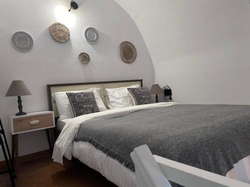 una camera con un grande letto e una parete bianca di Mare Nostrum Santo a Oia