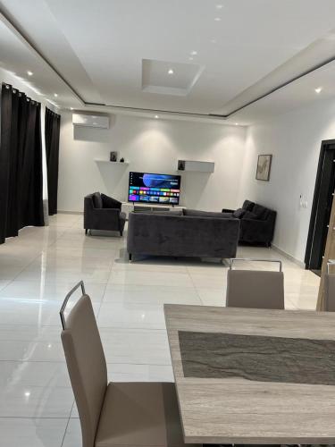 een woonkamer met een bank en een tv bij Appartement F4 in Dakar
