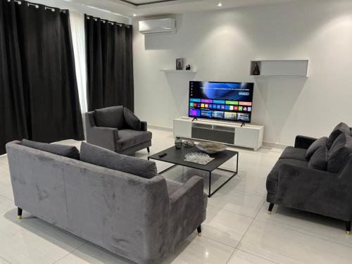 a living room with two couches and a flat screen tv at Appartement F4 in Dakar