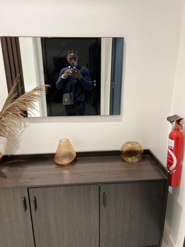 een man die een foto van zichzelf neemt in een spiegel bij Appartement F4 in Dakar