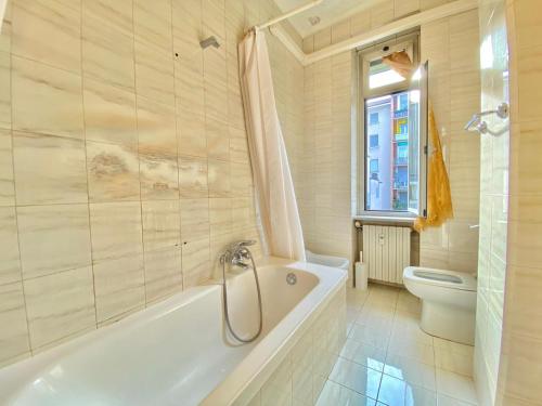 baño blanco con bañera y aseo en Graziosa in Washington, Milano City Life e Fiera Milano City en Milán
