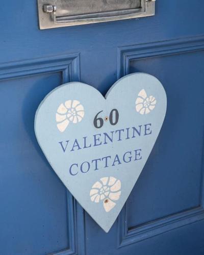 a heart sign on a blue door with the words go valentine coffee at Holiday Cottage with Beach Hut, Lyme Regis, Dorset in Lyme Regis