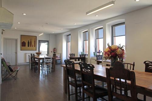 un comedor con una gran mesa de madera y sillas en Emebed Posada, en Castrojeriz