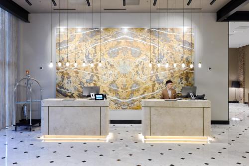 a woman sitting at a desk in front of a wall at Bomonti Arjaan by Rotana in Istanbul