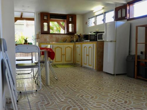 三河市Villa SaFran - Appartement Trois-Rivières的厨房配有黄色橱柜、桌子和冰箱。