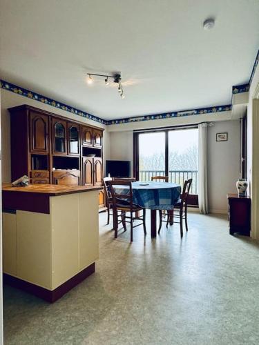 une cuisine et une salle à manger avec une table et des chaises dans l'établissement Le Seydrad, appartement vue nature, hauteurs de Gérardmer, à Gérardmer