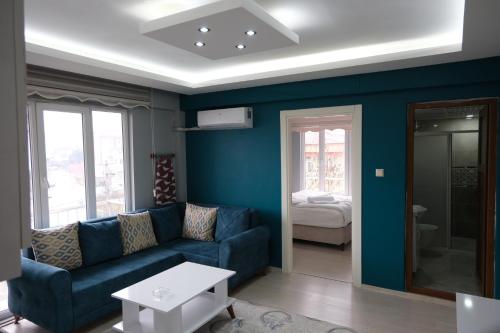 a blue living room with a couch and a bed at Çam Suit 
