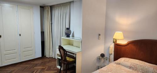 1 dormitorio con 1 cama y un jarrón en un estante en Nueva Cordoba en Córdoba