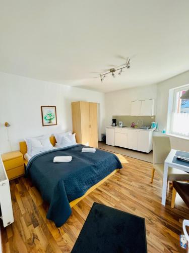 a bedroom with a large bed and a kitchen at Casa Benke Ház in Covasna
