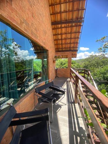 einen Balkon eines Hauses mit zwei Stühlen darauf in der Unterkunft Chalé Por do Sol in Caruaru