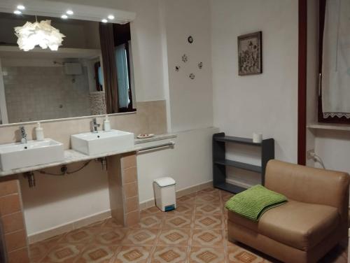 a bathroom with two sinks and a chair and a mirror at Verde Smeraldo in Salerno