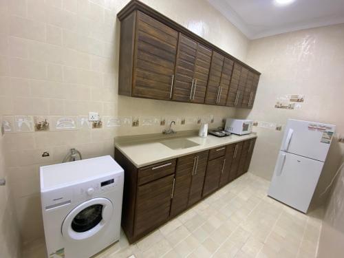 una pequeña cocina con lavadora y fregadero en شقق مساكن الاميره en Yanbu