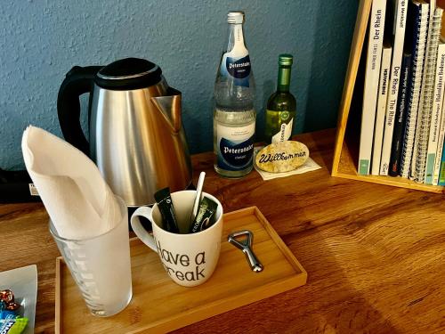 a wooden table with a coffee cup and bottles of wine at Touchdown21 in Karlsruhe