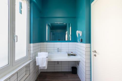 a bathroom with a white sink and a blue wall at The Time -Home & Hotel- in Santa Margherita Ligure