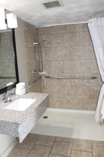a bathroom with a shower and a sink and a tub at Days Inn & Suites by Wyndham Springfield on I-44 in Springfield