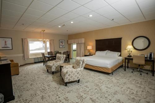 a bedroom with a bed and a desk and chairs at Peek'n Peak Resort Trademark Collection by Wyndham in Clymer