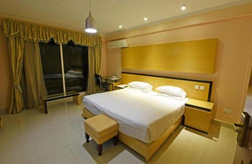 1 dormitorio con cama grande y ventana grande en Lake view property, en Kisubi