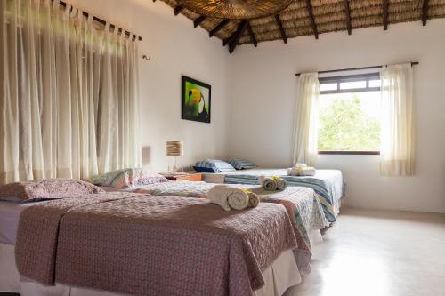 a bedroom with two beds and a window at Casa Bella Barra Beach in Barra Grande