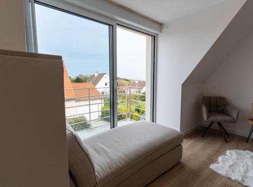 une chambre avec un lit et une grande fenêtre dans l'établissement Villa Cap, à Audinghen