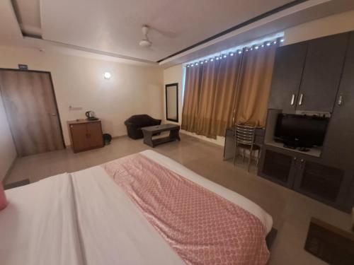 um quarto de hotel com uma cama e uma televisão em Hotel Diamond Airport Near TERMINAL 3 em Nova Deli