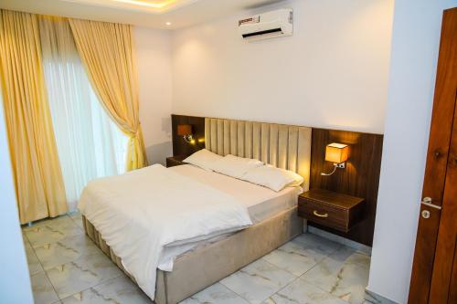a bedroom with a large bed and a window at Elim Maisonette in Lekki