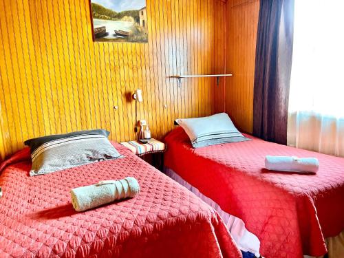 two beds sitting next to each other in a room at Hospedaje Familiar Doña Juanita in Puerto Montt