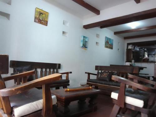 a living room with wooden benches and tables at Ríos Voladores Hostel in Bogotá