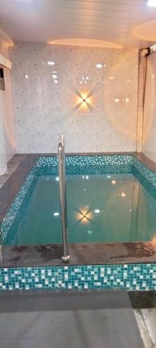 a swimming pool in a house with a tile floor at Dev Kirtan Villa in Daman