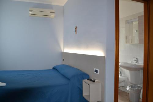 Hotel Immagine في سان جوفاني روتوندو: غرفة نوم بسرير ازرق ومغسلة