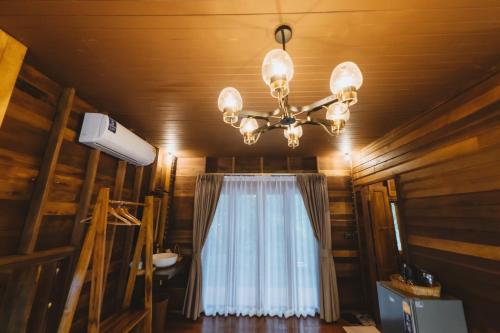 una lámpara de araña colgada del techo con una ventana en Sangkaew Phuthara, en Ban Pang Rim Khon