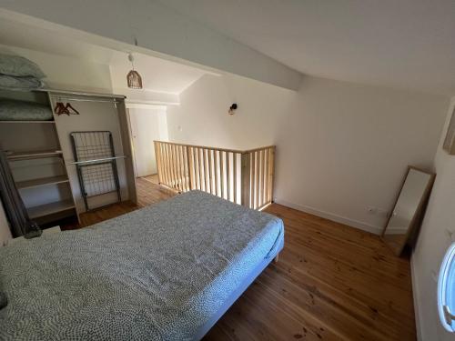 - une chambre avec un lit dans un dortoir doté de parquet dans l'établissement Beau P2, résidence avec piscine, à Aigues-Mortes