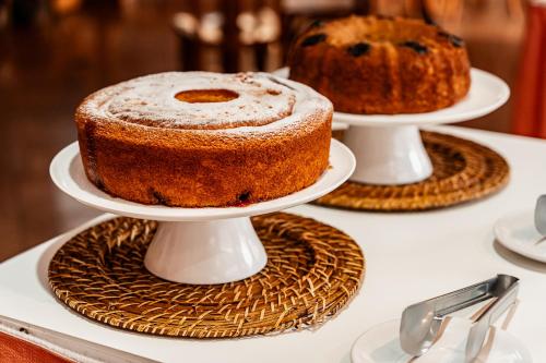 two cakes on three plates on a table at Champagnat Praia Hotel in Vila Velha