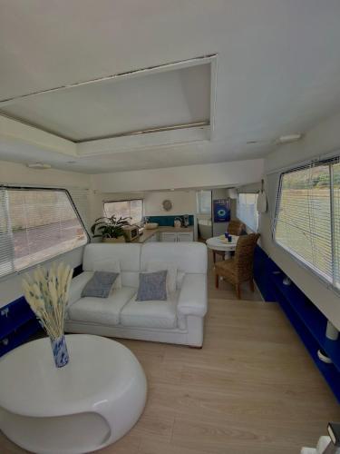 un salon avec un canapé blanc et une table dans l'établissement Bateau Mama Mia, à Narbonne