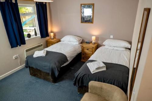 a bedroom with two beds and a chair and a window at The Malt Shovel Inn in Bridgwater