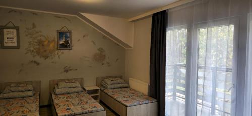 a room with two beds and a large window at Panorama in Kąty Rybackie