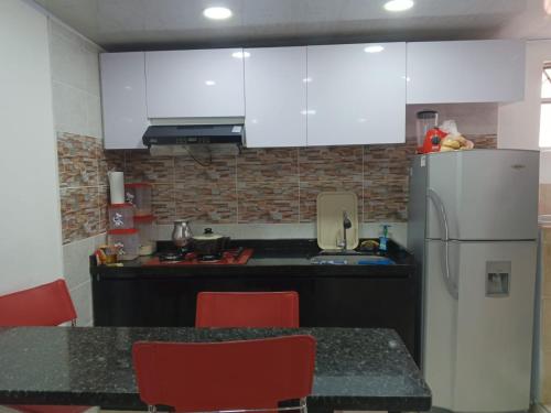 a kitchen with white cabinets and a white refrigerator at Tres Reyes apto in Soacha