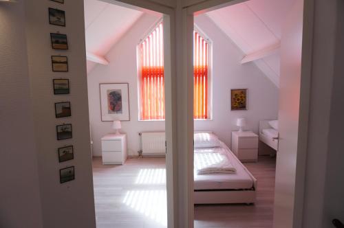 a bedroom with a bed and two windows at Kustverhuur, Breskens Zwin 077 in Breskens