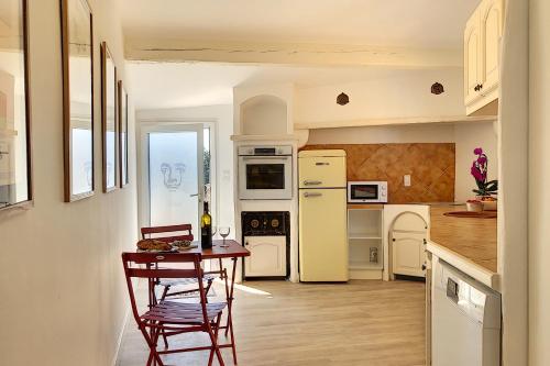 une cuisine avec une table et des chaises dans une pièce dans l'établissement Le Clos des Costes, au Beausset