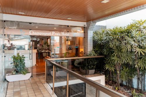 a store with plants in the front of a building at Champagnat Praia Hotel in Vila Velha