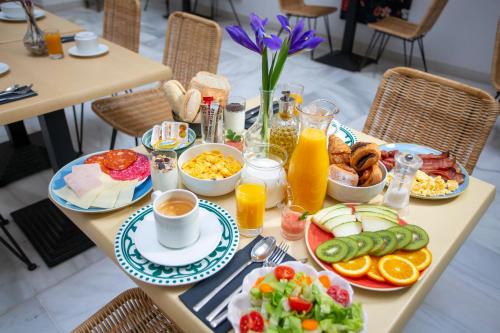 una mesa de desayuno con productos de desayuno y zumo de naranja en Casual con Duende Cadiz en Cádiz