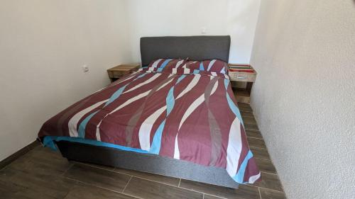 um quarto com uma cama com um edredão listrado em Apartman Baco em Žabljak