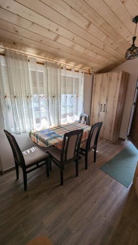 uma sala de jantar com uma mesa e cadeiras num quarto em Apartman Baco em Žabljak