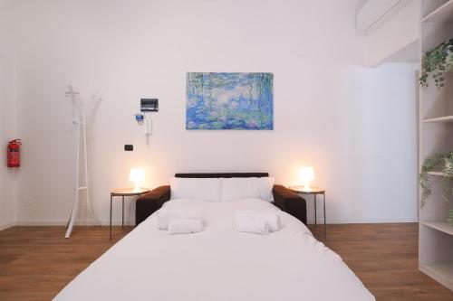 1 cama blanca en una habitación con 2 lámparas en Primopiano - Bignami, en Milán