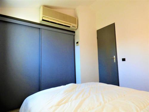 una camera con letto e armadio blu di Appartement wifi, piscine, spa, clim, +vélo à Arles en Camargue pour 6 pers a Arles