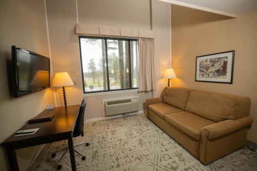 a living room with a couch and a desk and a television at Peek'n Peak Resort Trademark Collection by Wyndham in Clymer