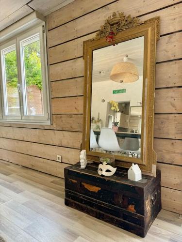 - un miroir dans une chambre dotée d'un mur en bois dans l'établissement Le Muguet, maison de caractère à Bénodet, à Bénodet