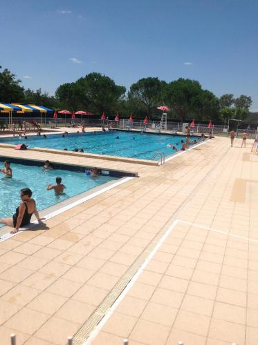 une grande piscine avec de nombreuses personnes dans l'établissement Ancien presbytere au coeur du village, à Mauvezin