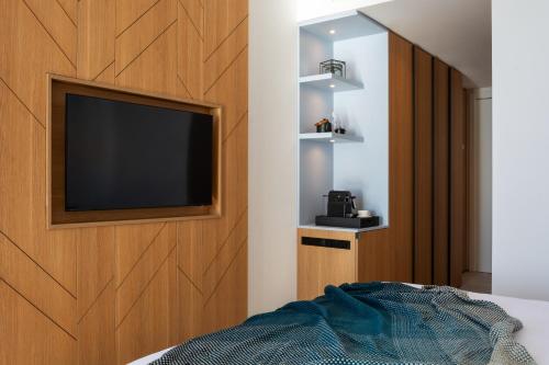 a bedroom with a flat screen tv on a wall at Hotel Ponta Plaza Conference & Spa in Budva